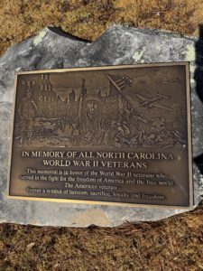 Photo-engraved bronze World War II memorial plaque with military artwork and tribute text